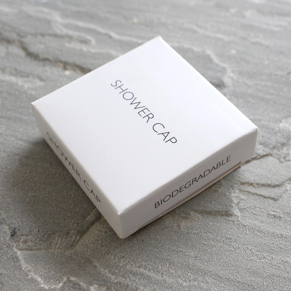 White Shower Cap Box on Grey tiled background