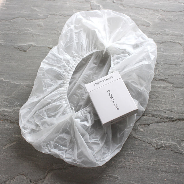 Biodegradable shower cap, opened with box by the side