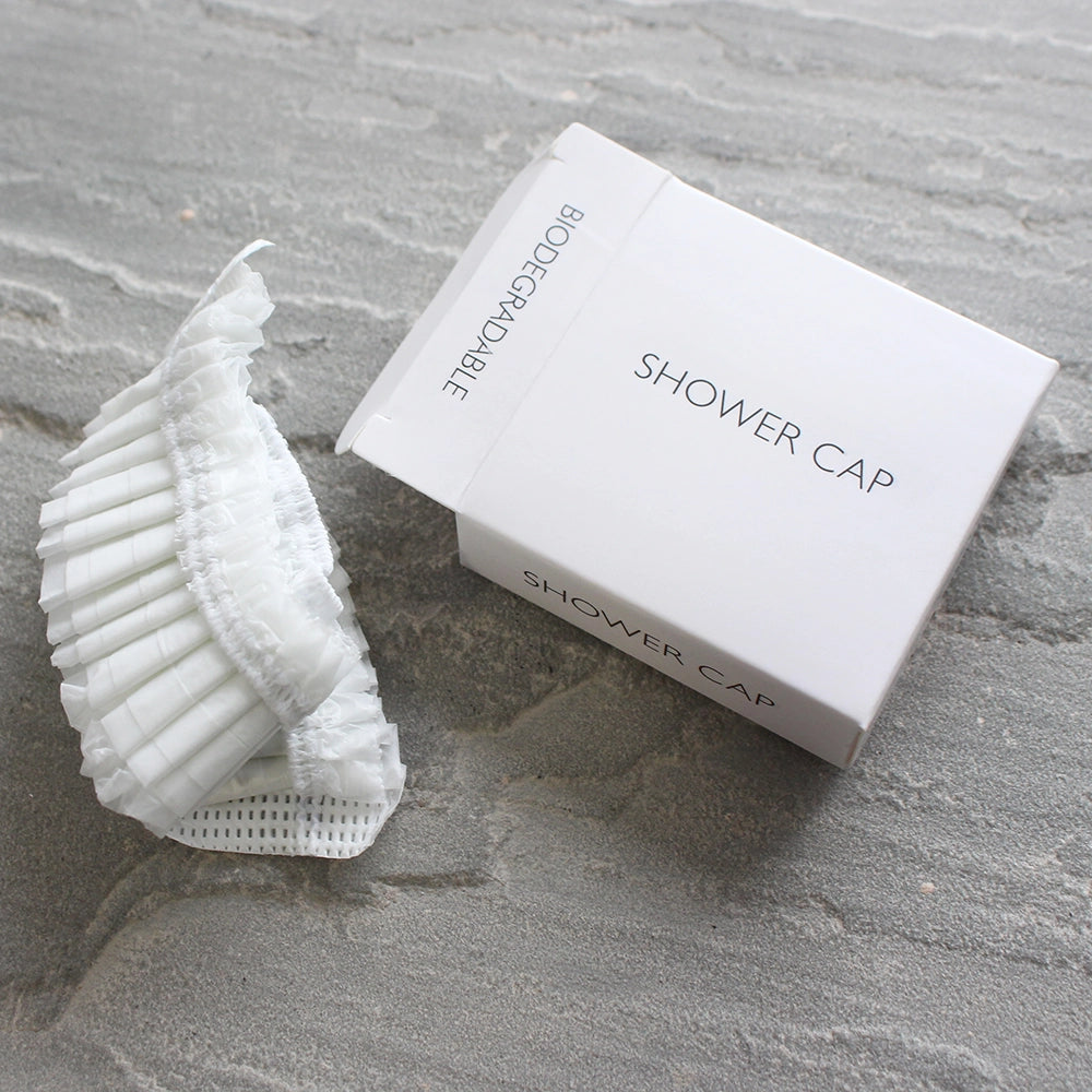 Open Box showing the folded biodegradable shower cap