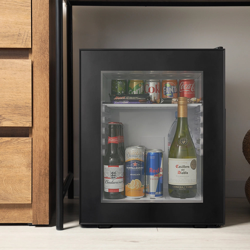 Small black refrigerator with drinks inside, next to wooden cabinets.