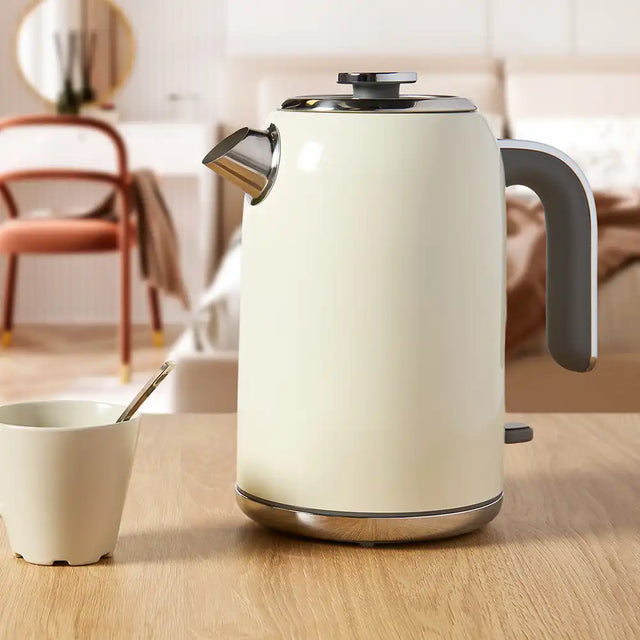 Cream electric kettle on a wooden table with a blurred background