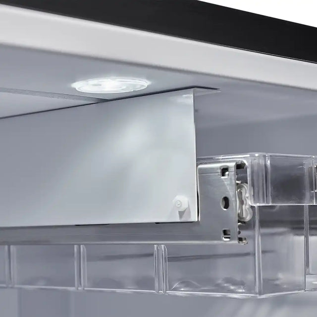 Close-up of a clear acrylic shelf with a metal bracket on a reflective surface.