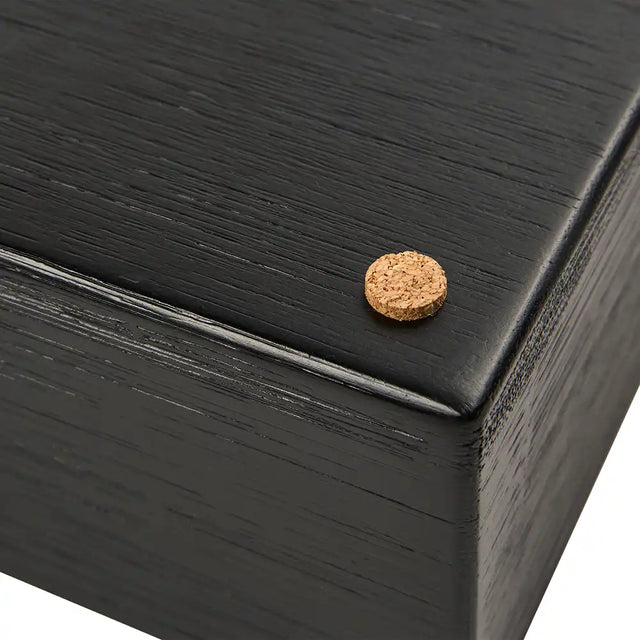 Close-up of a cork circle on a black wooden holder