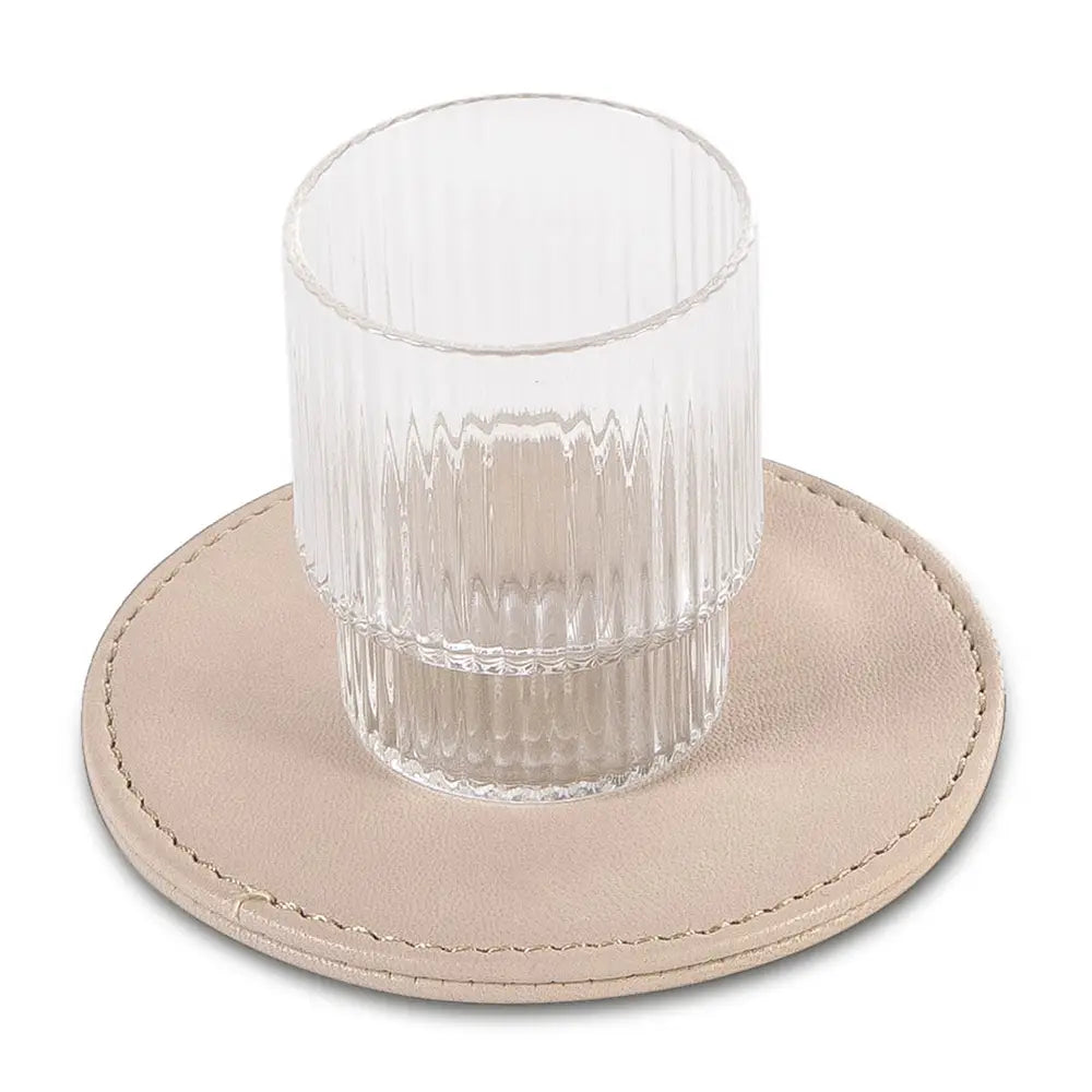 Clear glass on a beige leather-effect coaster with a white background