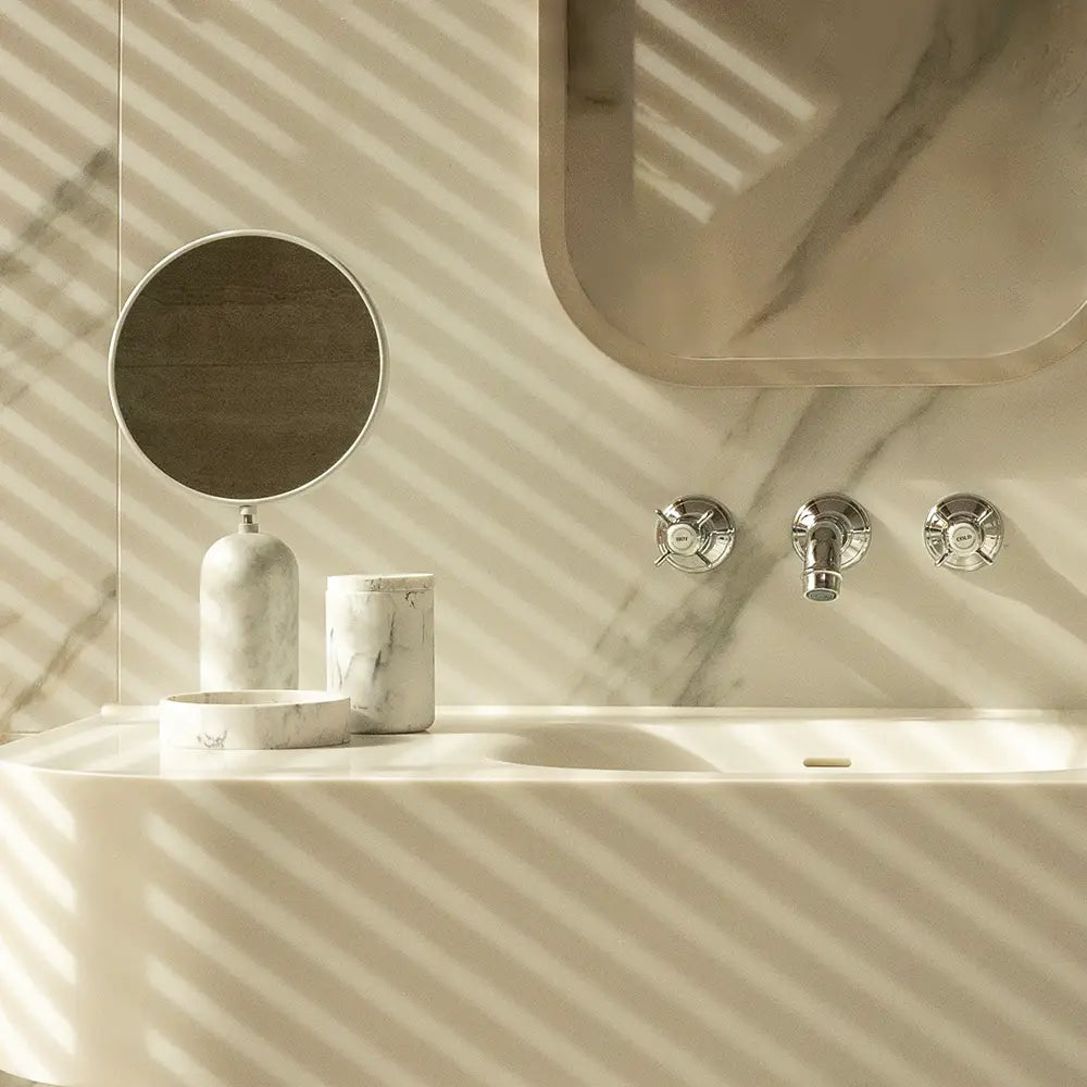 Bathroom setup with a sink, mirror, and Toba Jar on a marble background.