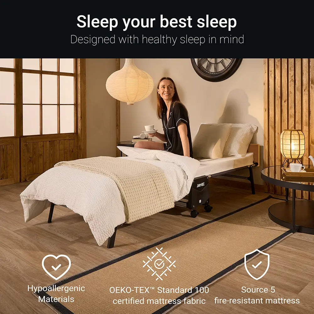 Woman in a bedroom setting with a bed, pillows, and a lamp.