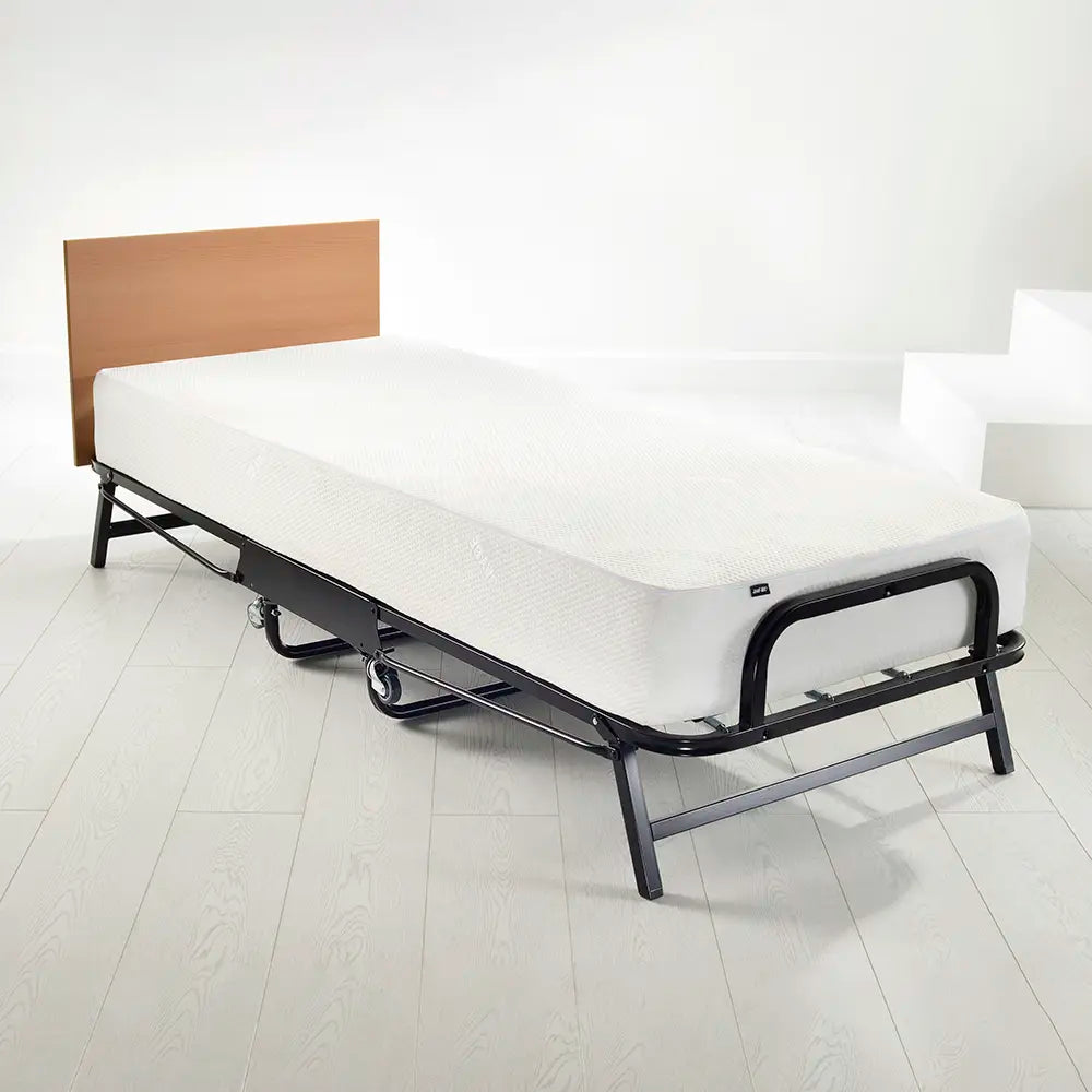 Bed with white mattress on a white floor and wall