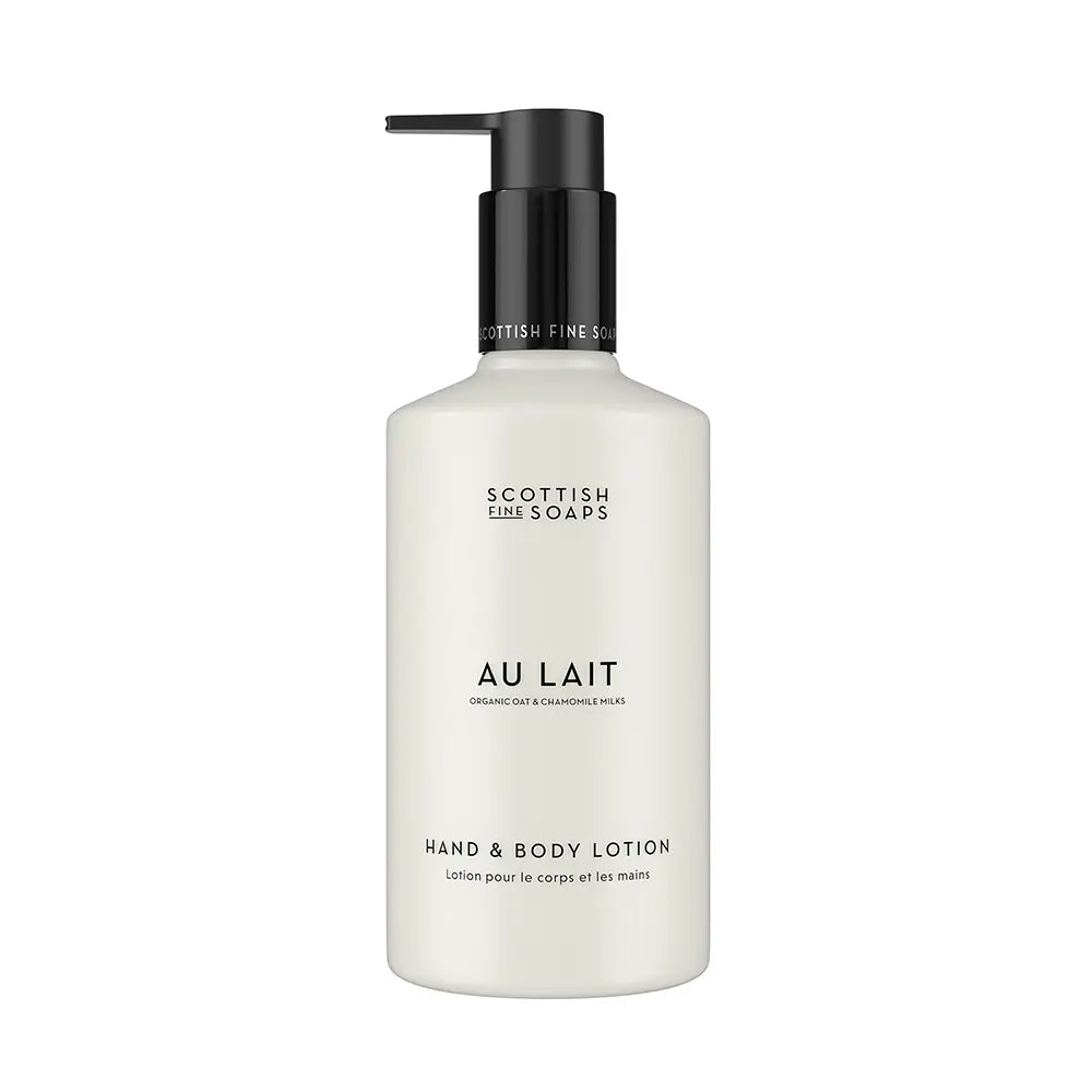 A bottle of Scottish Fine Soaps 'Au Lait' hand and body lotion, featuring a matte white bottle and a black pump dispenser, set against a plain white background.