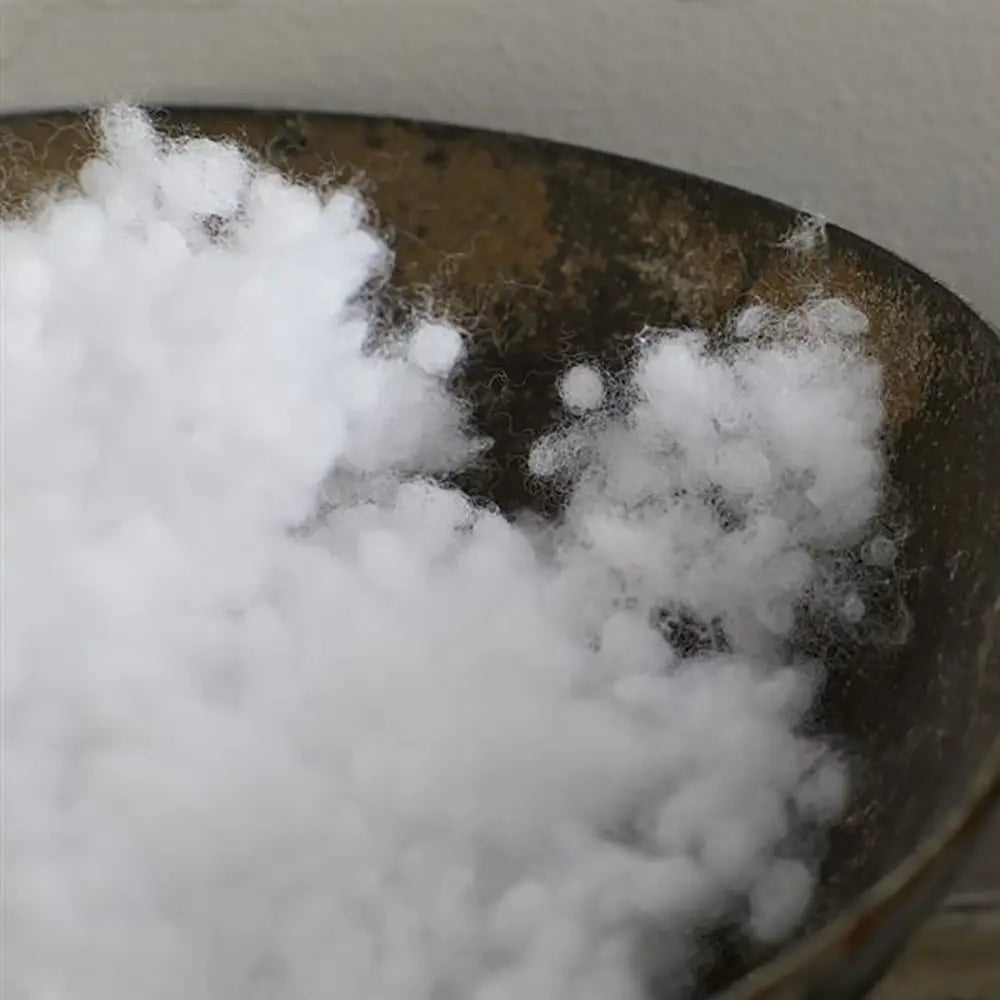 White cotton in a brown bowl against a neutral background