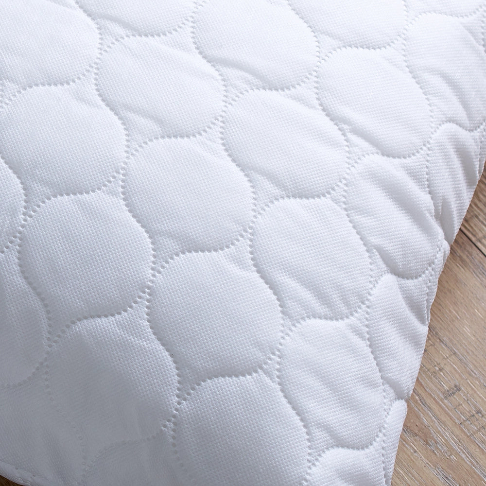 Close up of white quilted pillow protector with embossed design