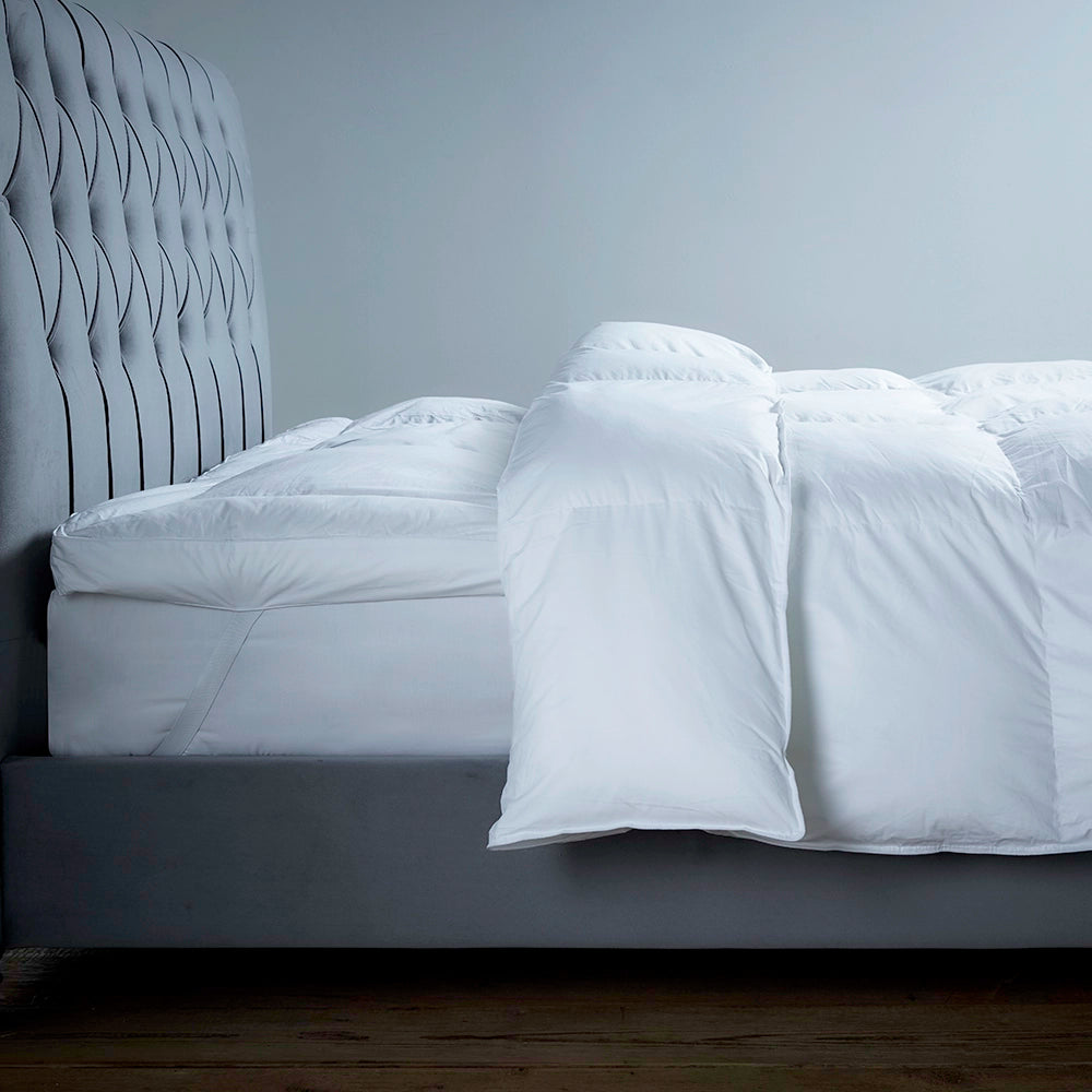 Luxury eco topper on a bed, showing corner securing straps with matching duvet