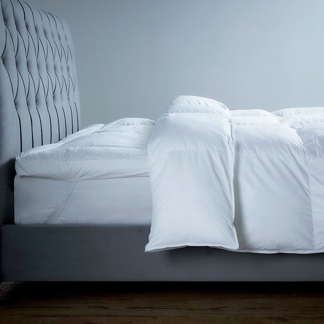 Luxury eco topper on a bed, showing corner securing straps with matching duvet