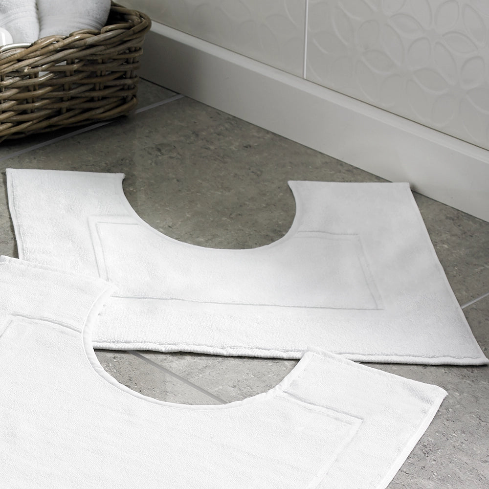 Smallest ever pedestal shaped bathmat in white on a tiled floor