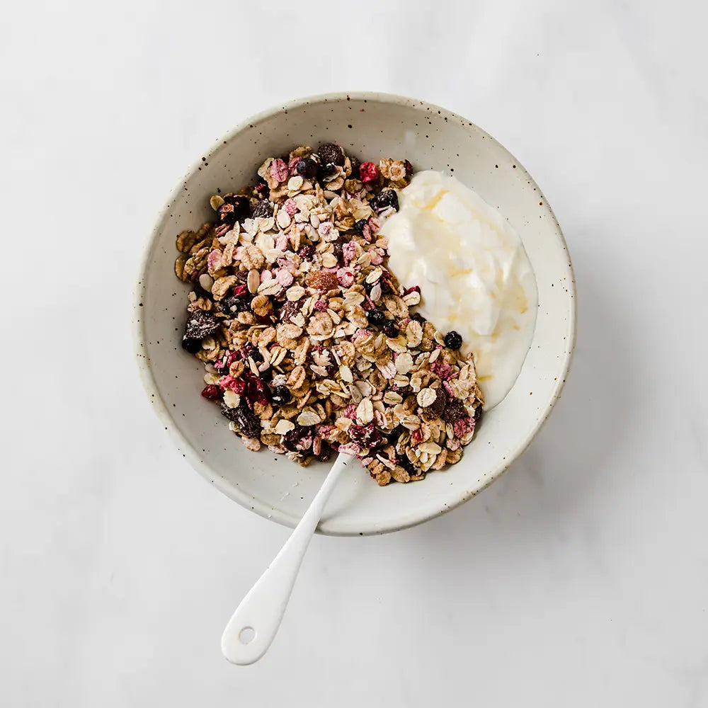 Bowl of granola with yogurt on a white background