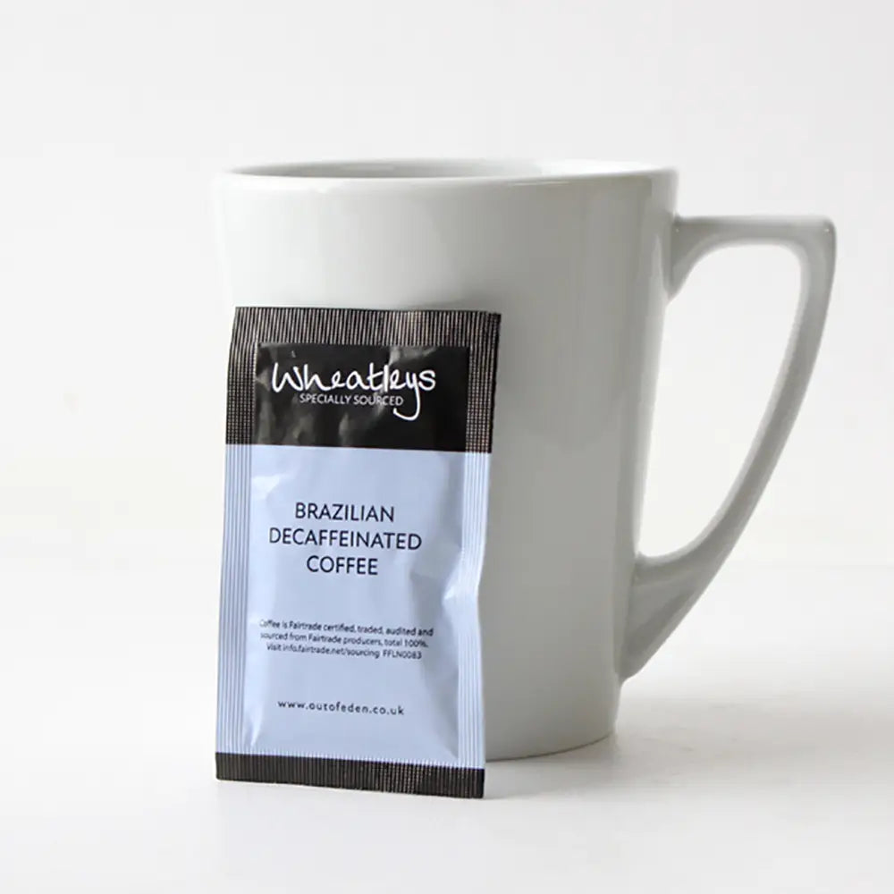 Wheatleys Brazilian Decaffeinated Coffee package in front of a white mug on a white background