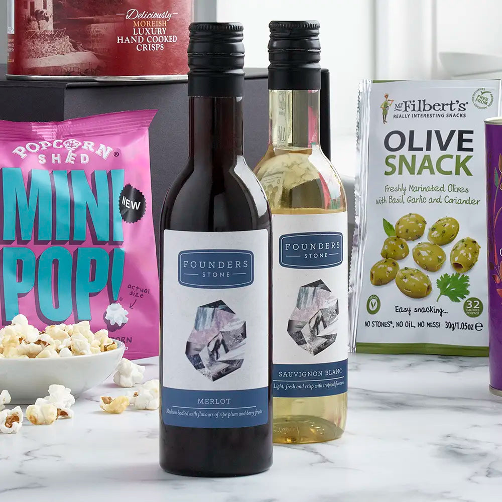 Two bottles of Founders wine on a marble surface with snacks and popcorn in the background.