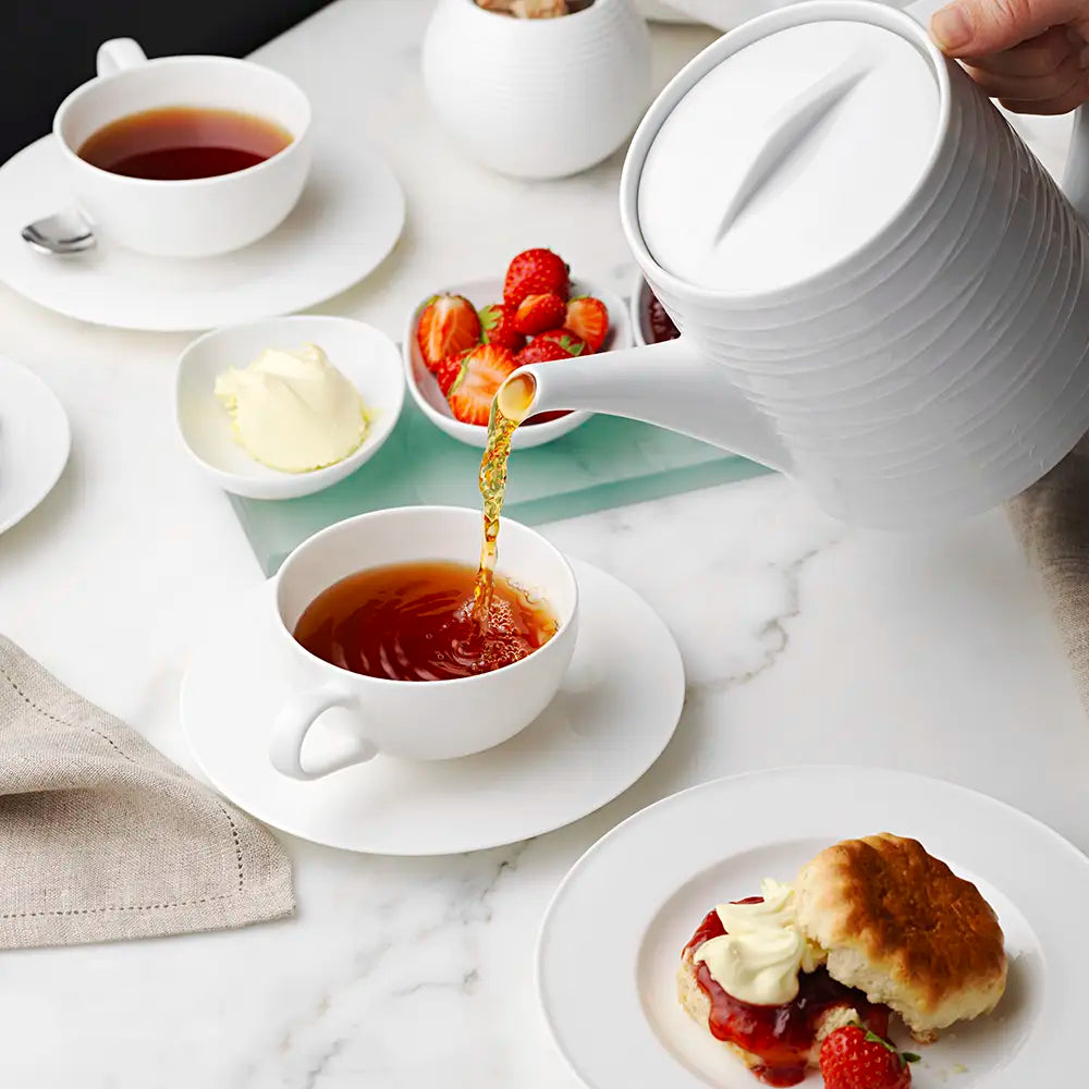 Fresh brewed tea being poured from a tea pot during afternoon tea made with tea bags from Birchall