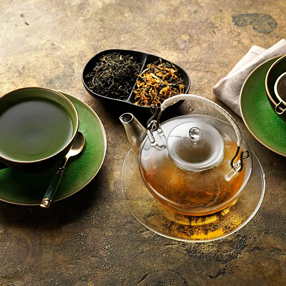 Birchall Mao Feng Green Tea brewed in an ornate glass tea pot and served in green ceramic cups