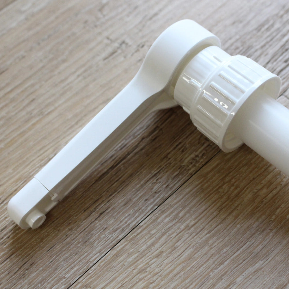 Close up image of the top of hand pump, showing screw cap and dispenser nozzle