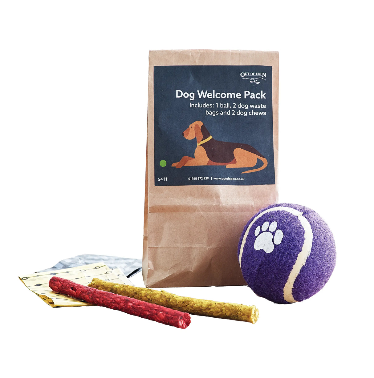 Dog Welcome Pack with ball, treats, and waste bags on a wooden surface.