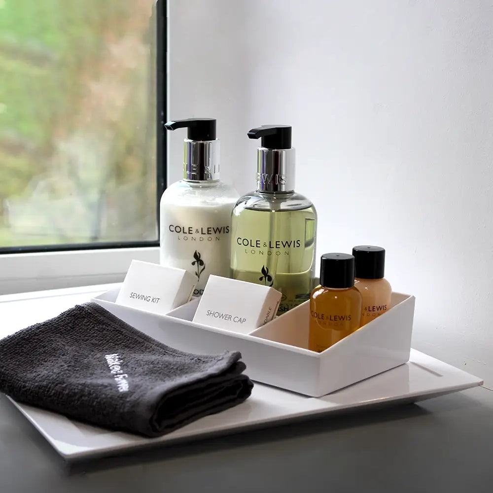 White melamine Hospitality Tray with Cole & Lewis products and face towel on a tray by a window