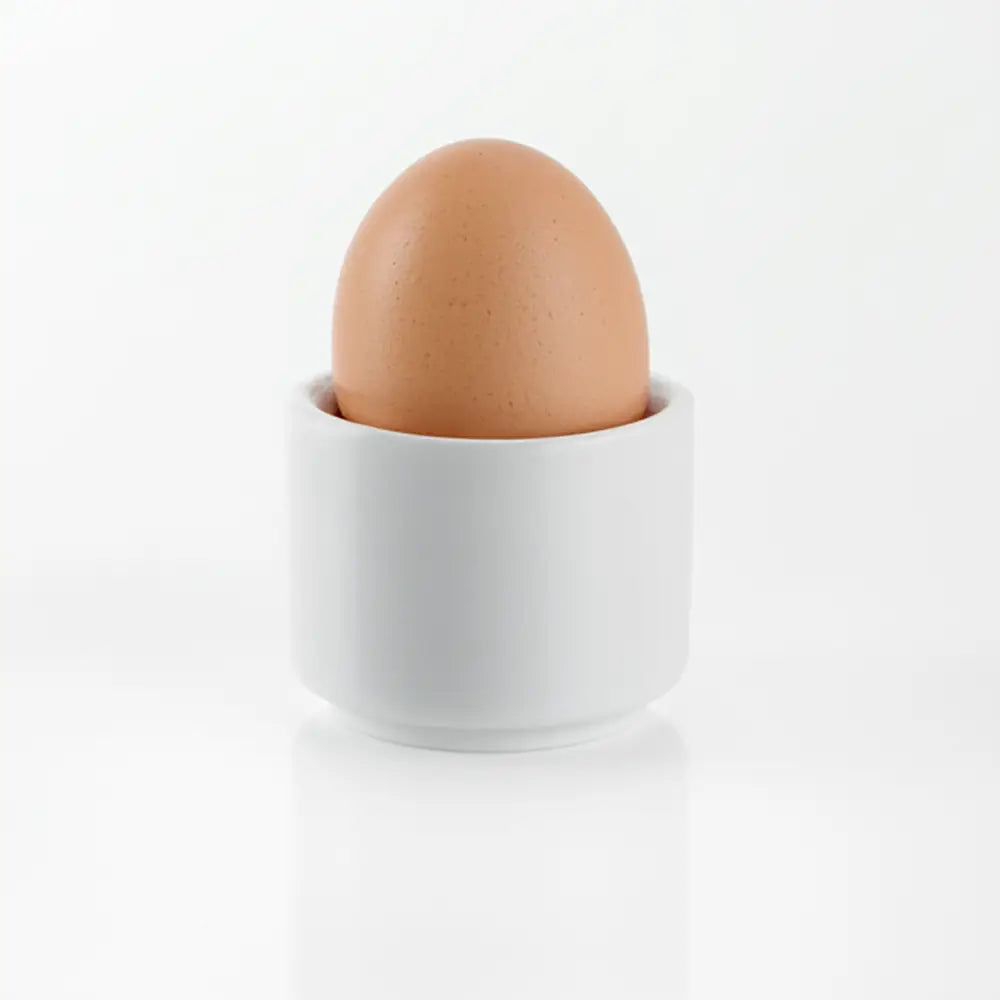 Brown egg in a white ceramic cup on a white background