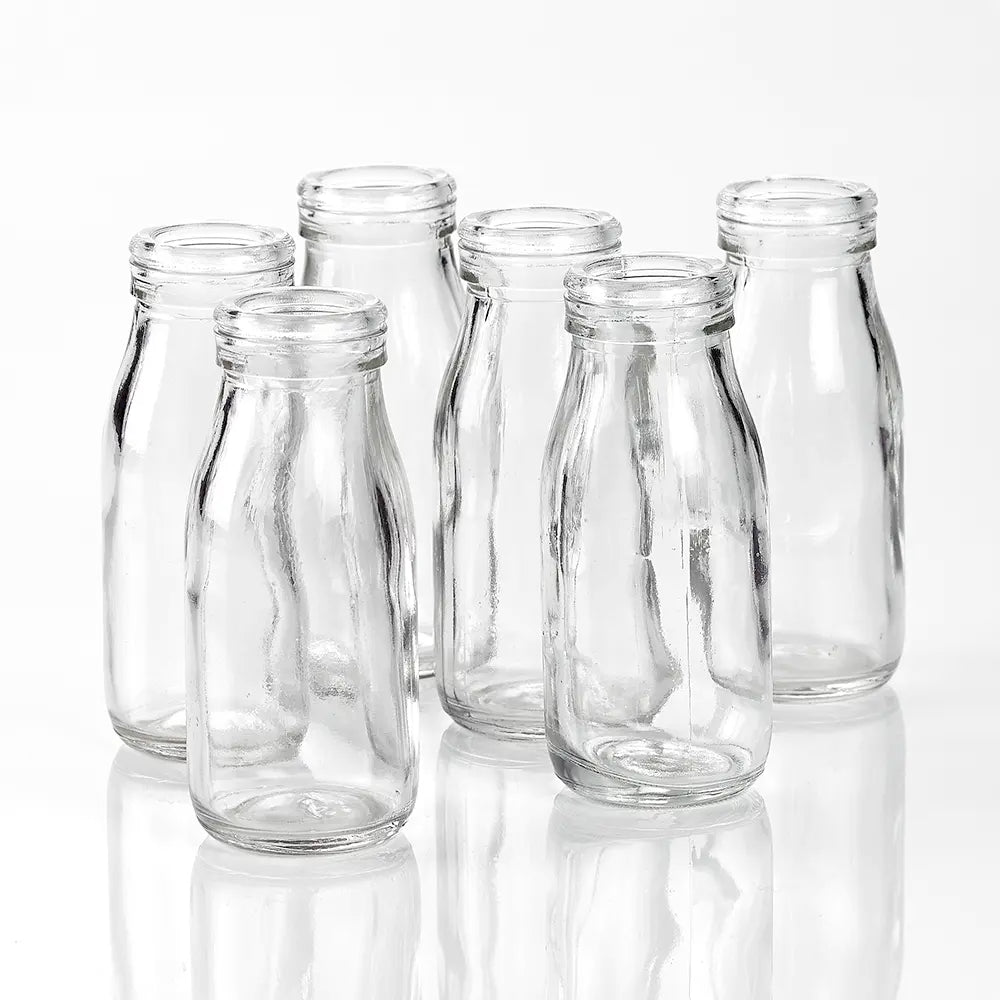 Set of six clear glass bottles on a white background