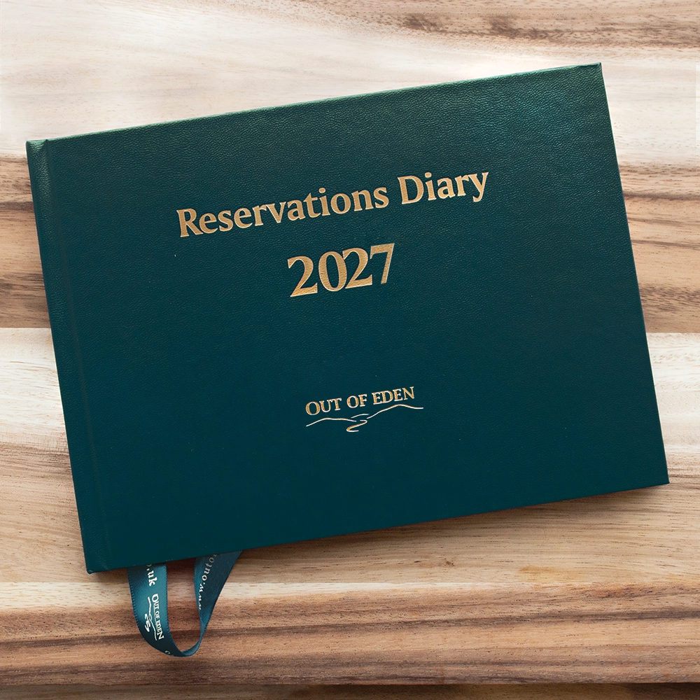 Green 'Reservations Diary 2027' on a wooden surface with 'Out of Eden' branding.
