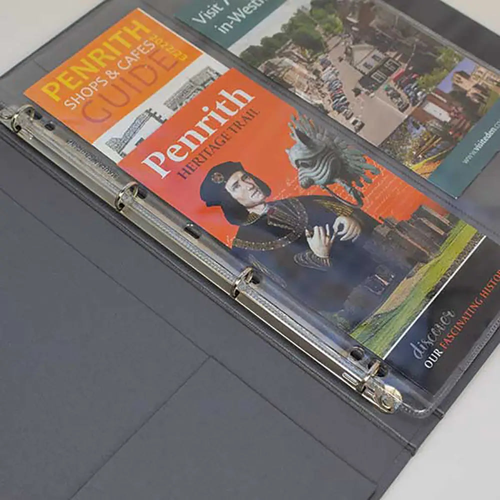 Grey Guest information folder with open pages showing travel guides or brochures.