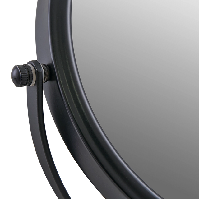 Close-up of a vanity mirror corner with a black knob on a white background