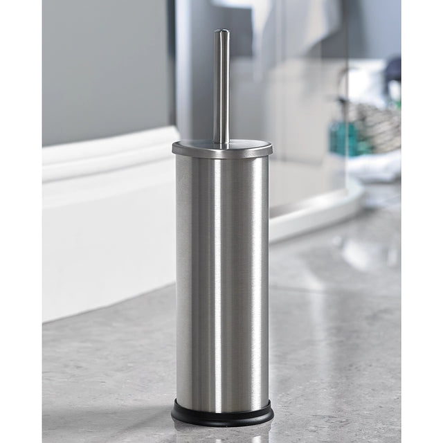 A satin stainless steel toilet brush with a black plastic base, placed on a light grey surface, possibly a bathroom counter.
