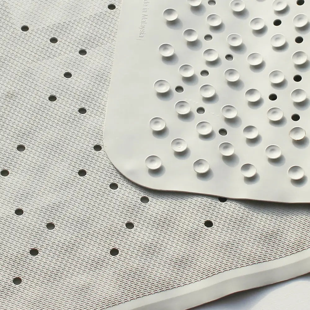 Close-up of a textured mat with circular and square patterns on a white background showing rubber suckers for superior grip and stability