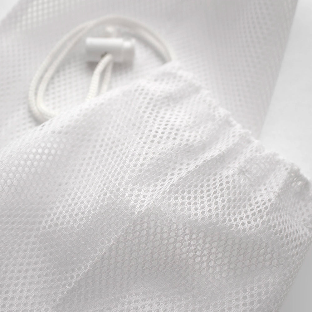 Close up detail of mesh storage bag fabric and spring toggle closure