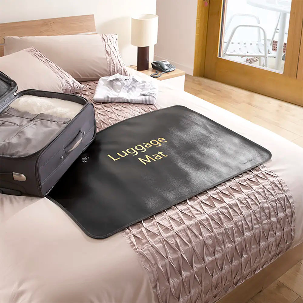 Luggage mat on a bed with an open suitcase next to it, in a bedroom setting.