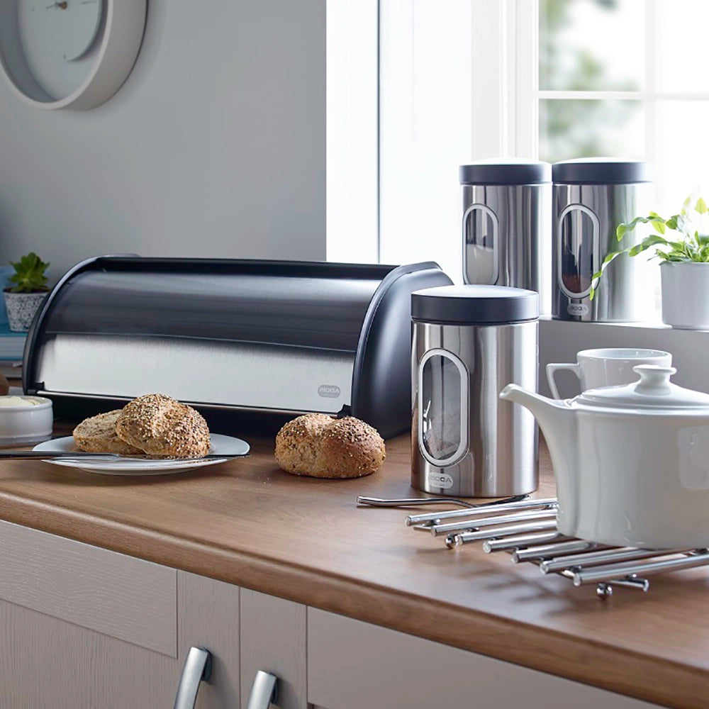 Lifestyle of stainless steal breadbin featuring Kitchen counter with bread, containers, and a teapot in a modern setting