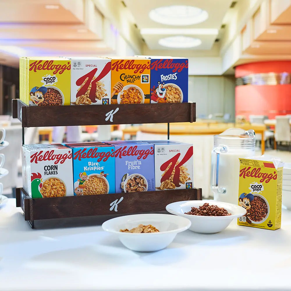 Display of Kellogg's cereal boxes and bowls with cereal on a table.
