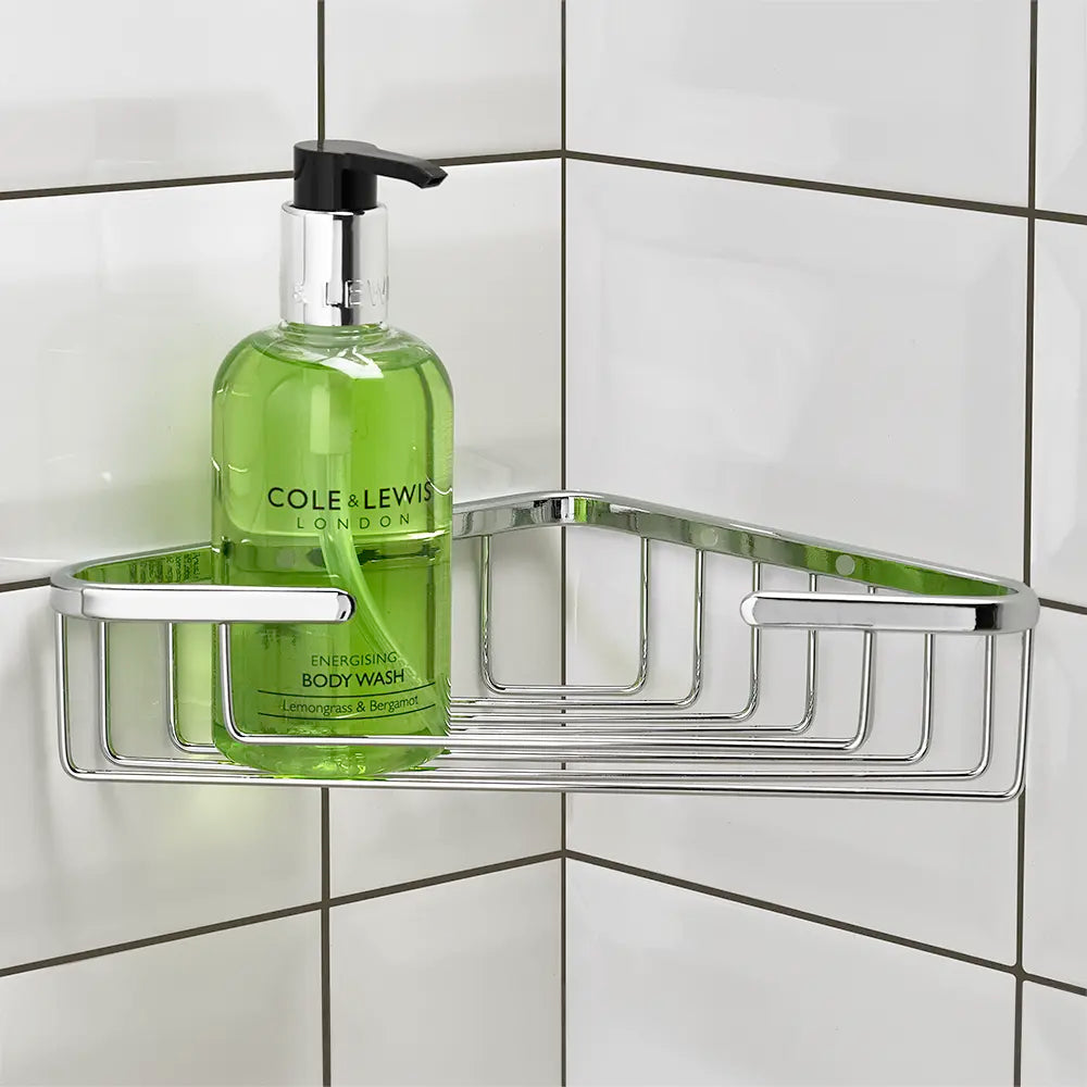 Green bottle of Cole & Lewis body wash on a metal corner shower caddy against a tiled wall.