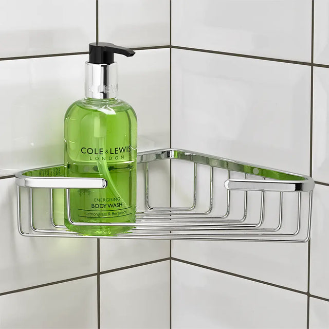 Green bottle of Cole & Lewis body wash on a metal corner shower caddy against a tiled wall.