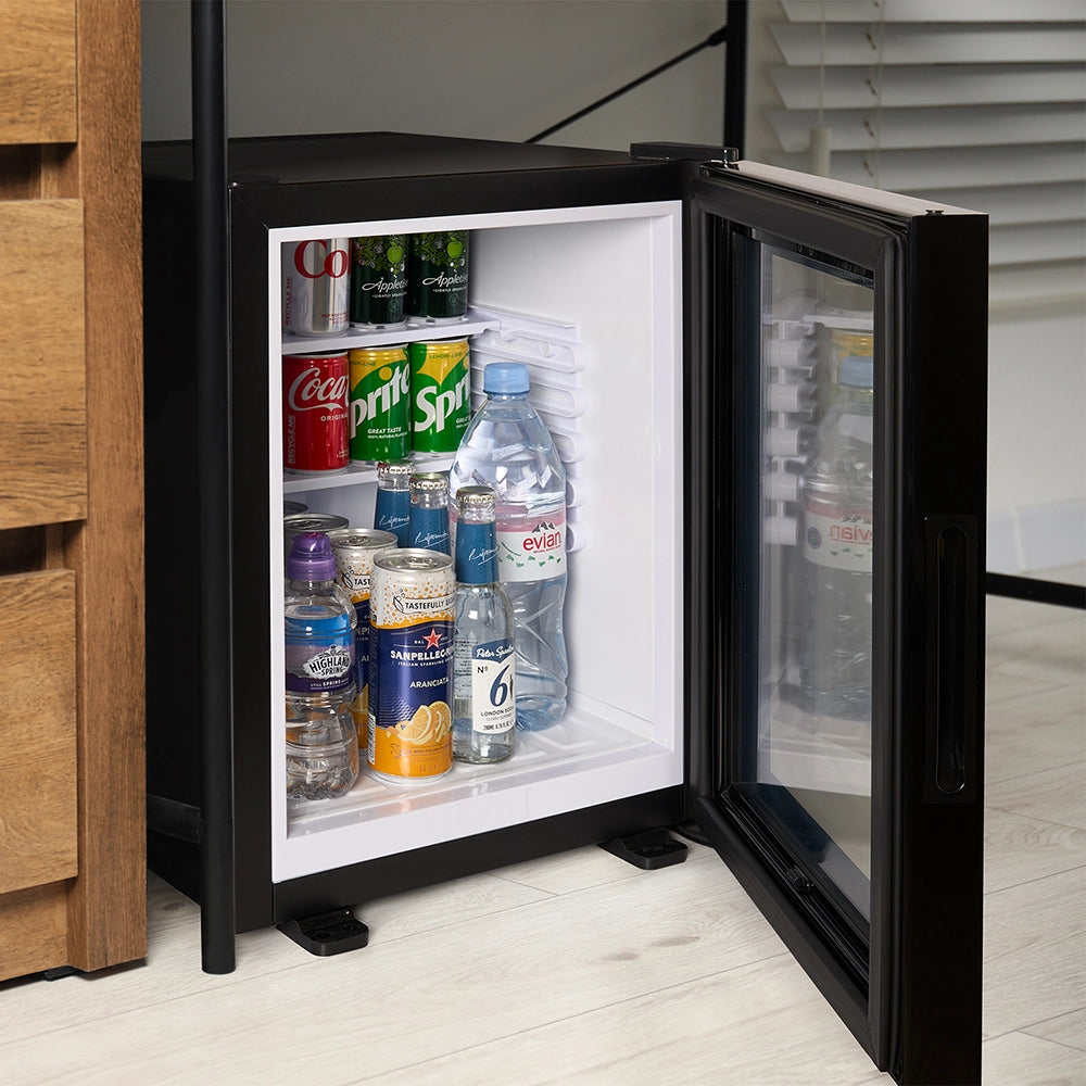 Small refrigerator with open door displaying various drinks on a wooden floor.