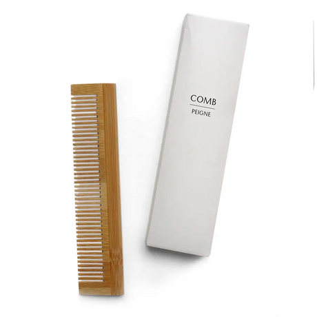 Wooden bamboo comb and white box labelled with Comb on a white background