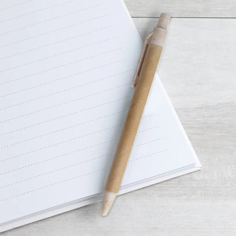 Recycled paper pen on a notebook with a light grey textured surface