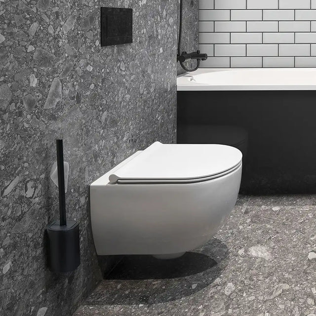 Modern wall-mounted toilet in a bathroom with grey walls, a white tiled area and a black toilet brush