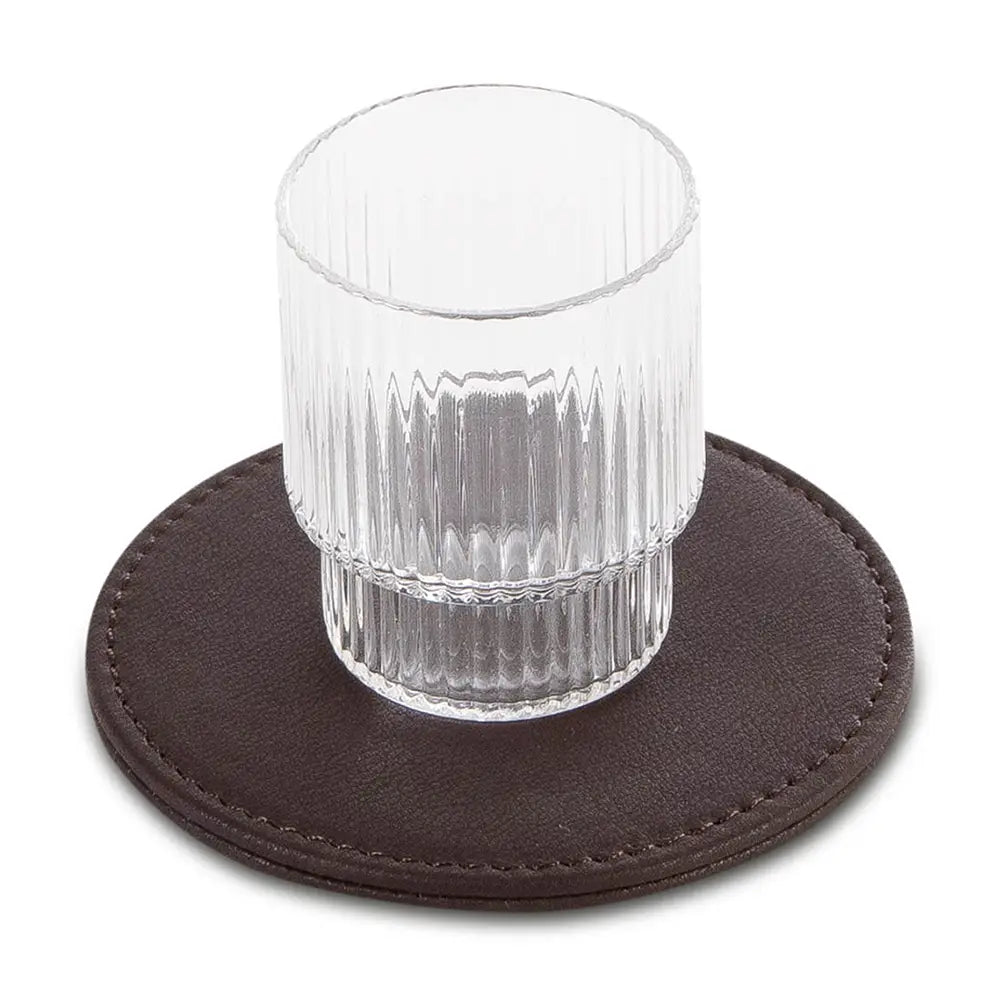 Clear glass on a brown leather-effect coaster with a white background