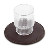 Clear glass on a brown leather-effect coaster with a white background