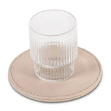 Clear glass on a beige leather-effect coaster with a white background