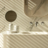 Bathroom setup with a sink, mirror, and Toba Jar on a marble background.