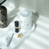 Cosmetic products on a marble tray next to a Toba jar