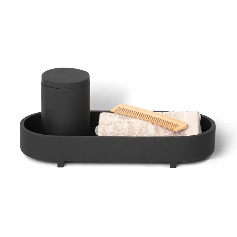 Black tray with cylindrical container, towel, and comb on a white background