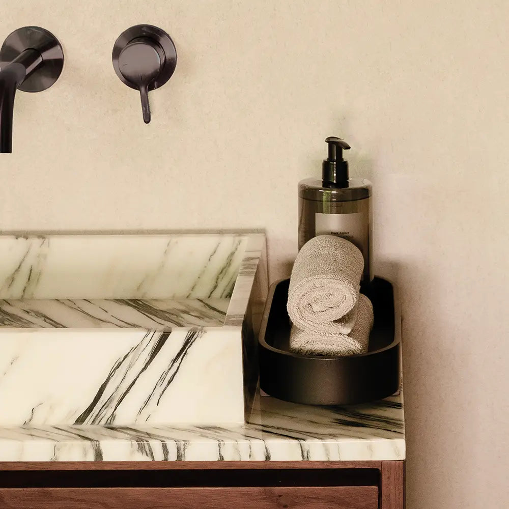 Black Monti amenity tray and a rolled towel