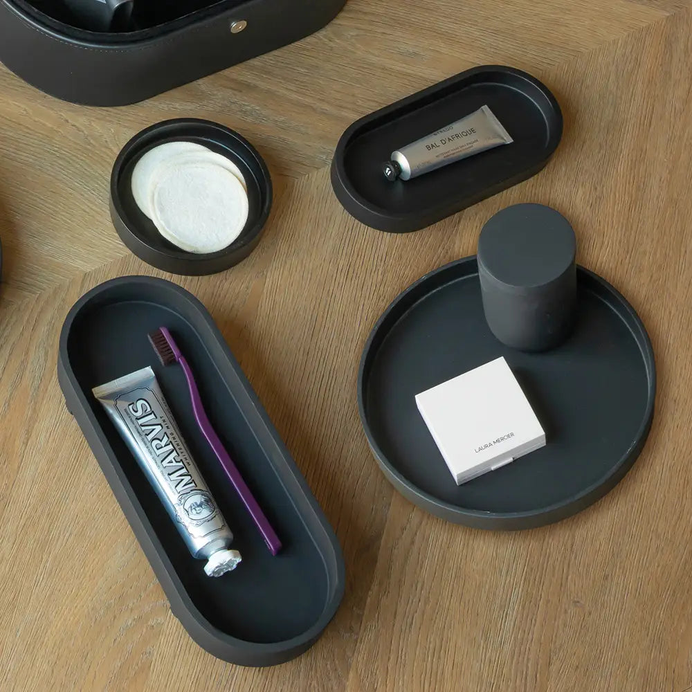 Black trays with toiletries on a wooden surface